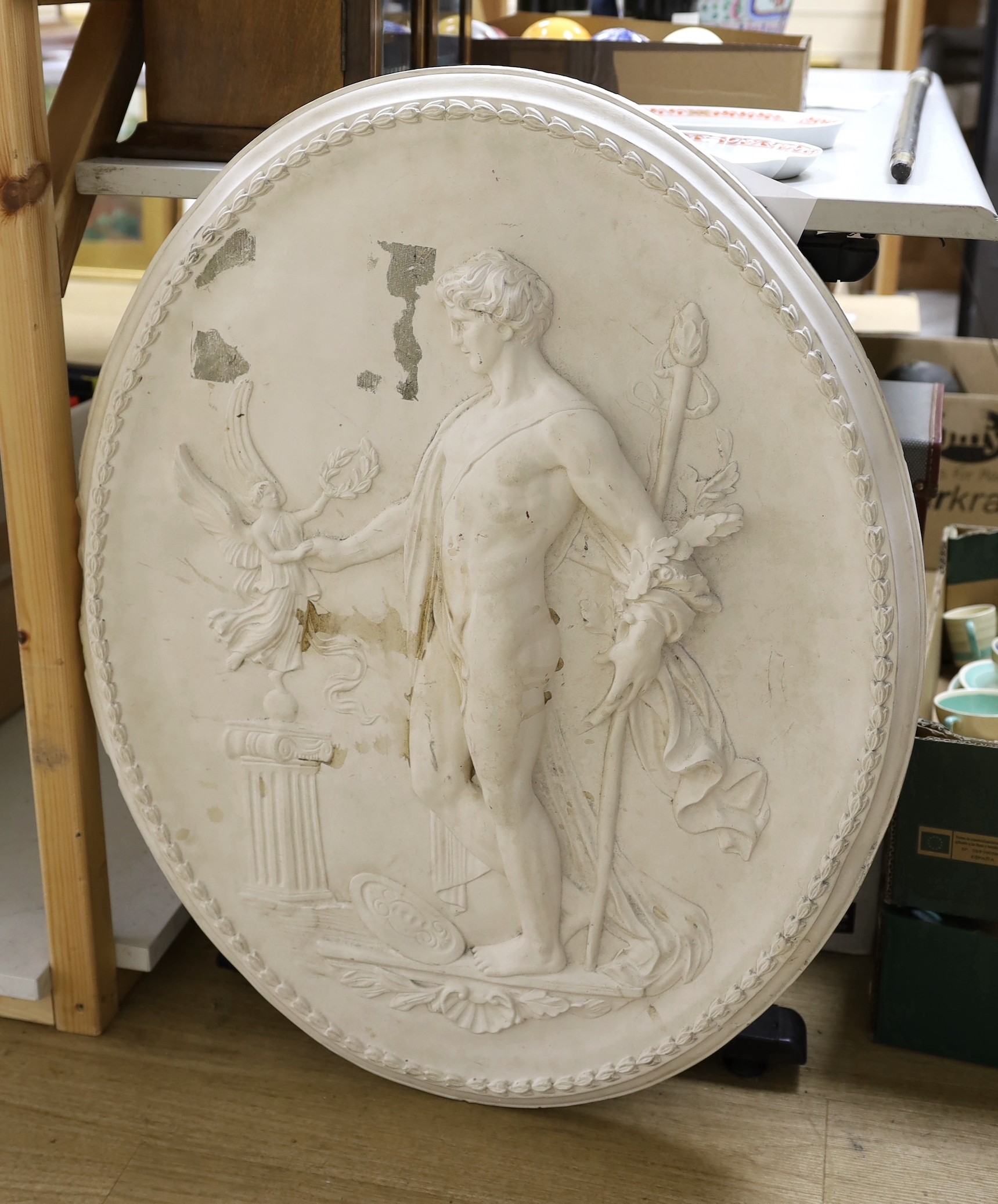 A cast plaster oval figural plaque